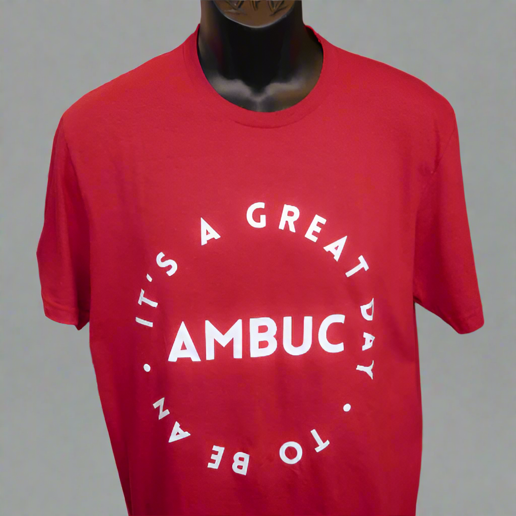 red t-shirt with the words "it's a great day to be an" written in a circle.  The word AMBUC is written in the middle of the circle with the other words surrounding.  
