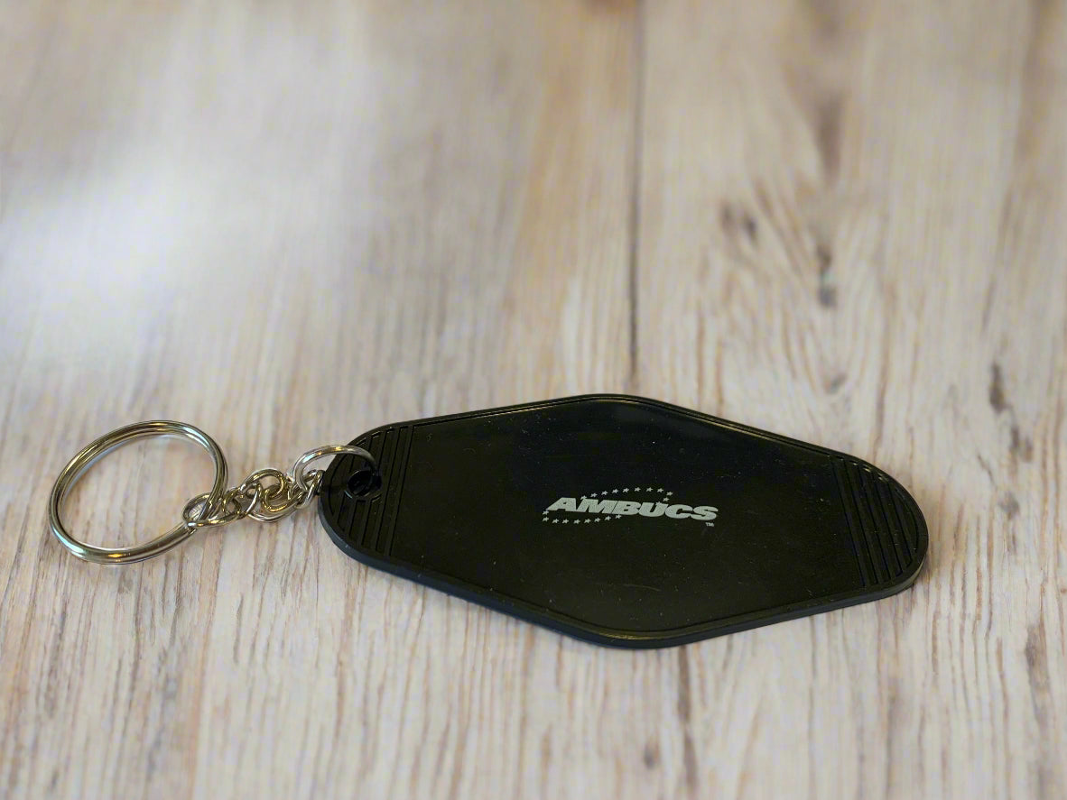 Black keychain with 'AMBUCS' logo on a document