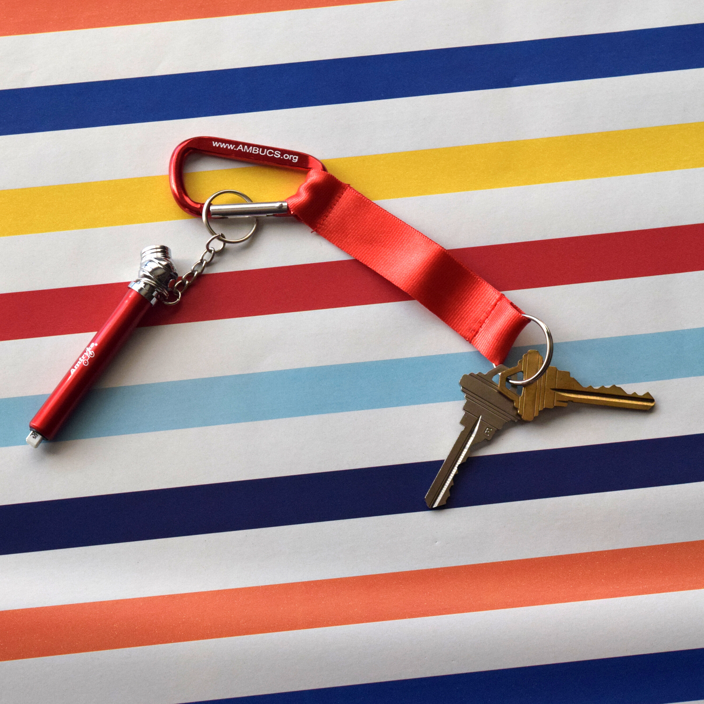 Red carabiner with a red tire gauge and keys attached 